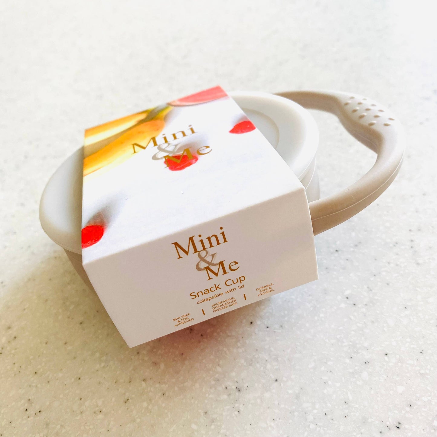 A beautiful lifestyle shot of Mini & Me Snack Cup Collapsible with Lid Almond in almond, ice-blue and kale-green by Cuddle...