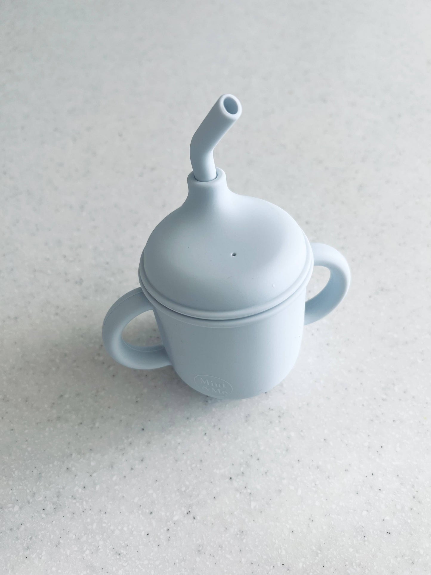 The Mini & Me Transitional Straw Sippy Cup Ice Blue in almond, ice-blue and kale-green styled beautifully on a shelf in a ...