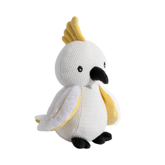 A child happily holding the Knitted Toy - Colin the Cockatoo in a sunlit nursery.