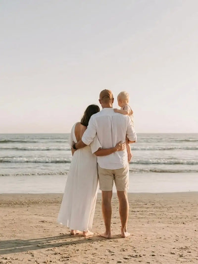 Family standing together at the beach watching the horizon — cherishing tiny moments that matter