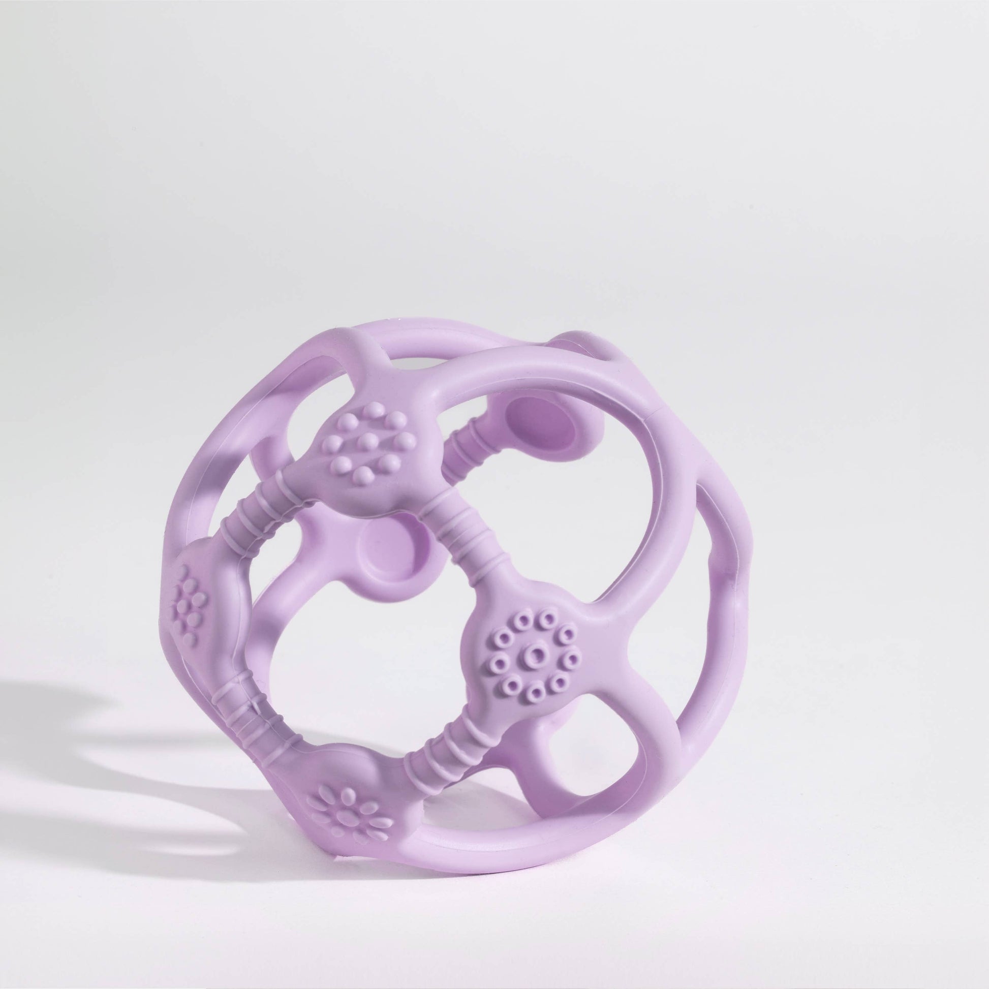 The Playground Silicone Teething Ball - Light Purple styled beautifully on a shelf in a child's bedroom.