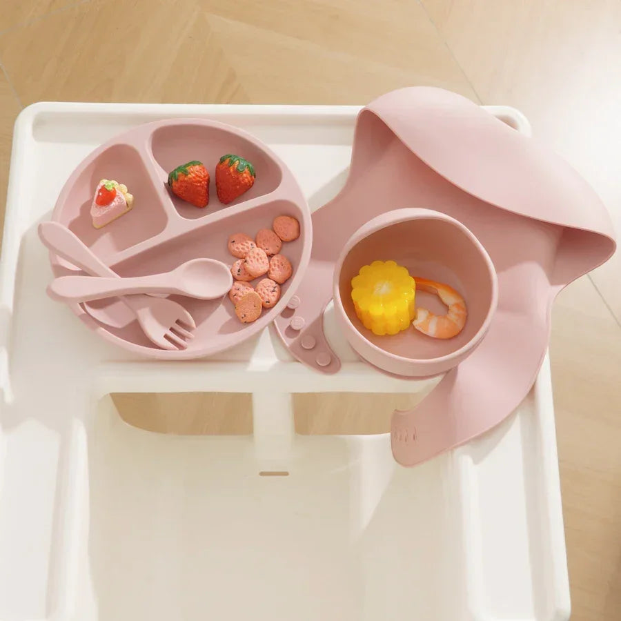 Complete feeding set showing plate, bowl, bib, cup and utensils