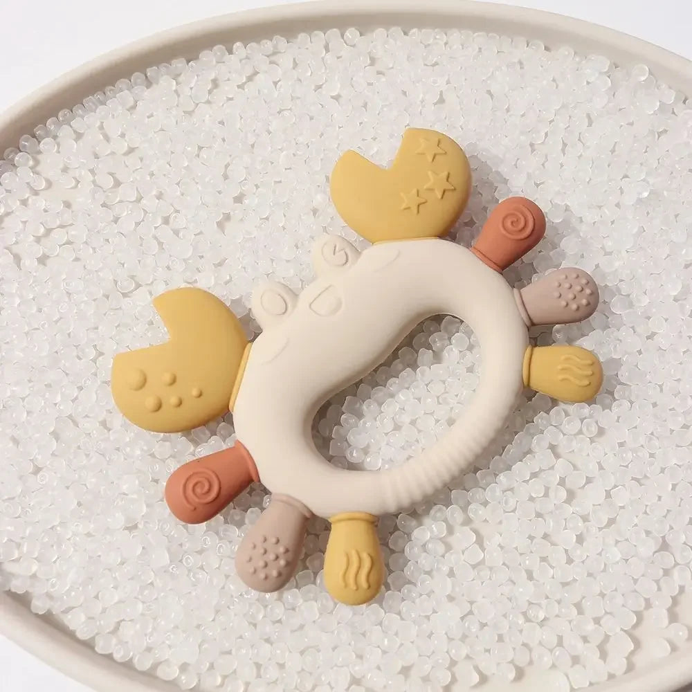 Crab-shaped silicone baby teether in multiple colors on white background