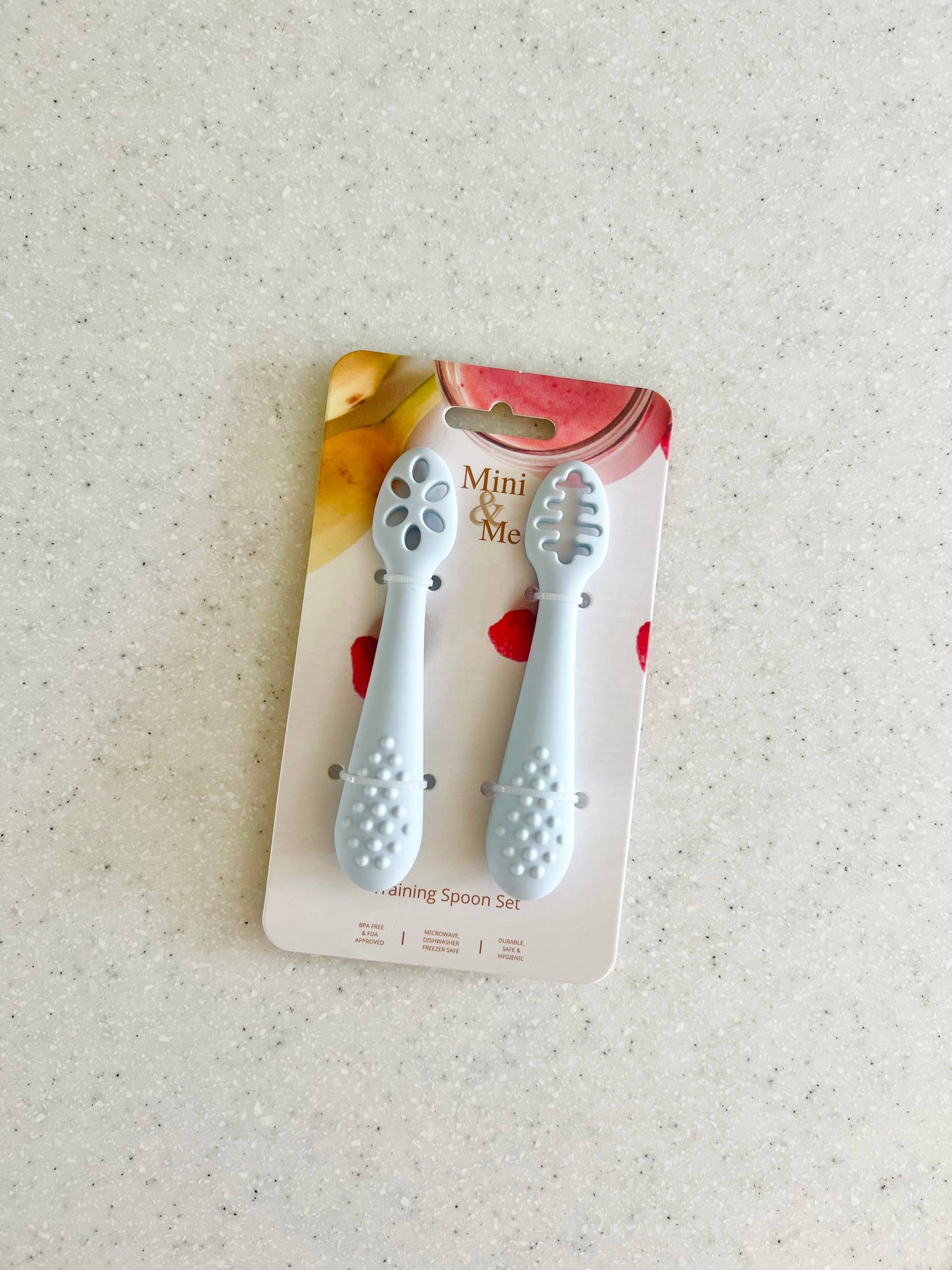 A beautiful lifestyle shot of Mini & Me Training Spoon Set Ice Blue in beige, animal and brown by Cuddle Bug & Co in a hom...