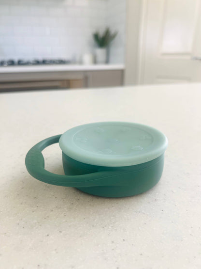 A beautiful lifestyle shot of Mini & Me Snack Cup Collapsible with Lid Kale in almond, ice-blue and kale-green by Cuddle B...